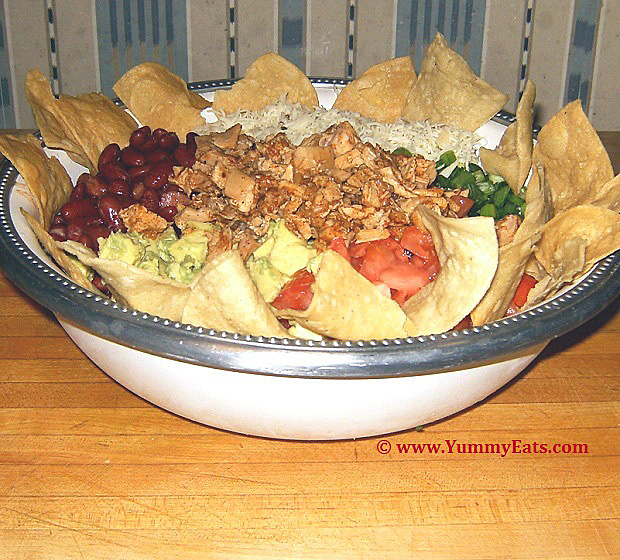 Taco Salad Bowl loaded up with Tortilla Chips and assorted toppings.